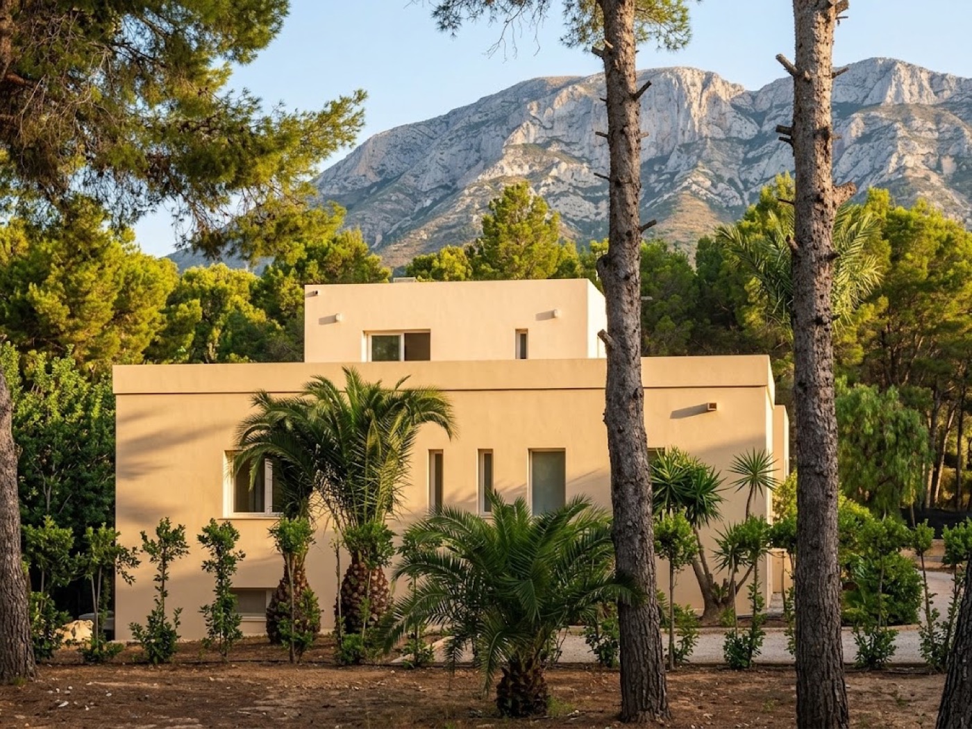 Vivienda terminada en Denia, con fachada en tono arena, palmeras y el Montgó al fondo